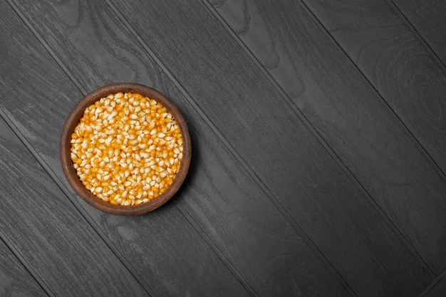 ceramic plate with corn kernels on the black wooden table