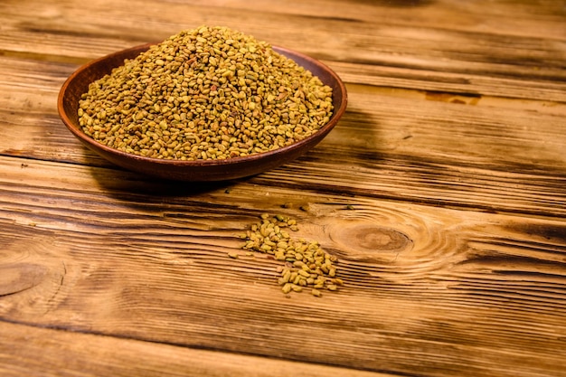 Ceramic plate with fenugreek seeds on rustic wooden table