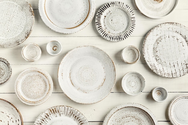 Ceramic plates of different sizes on a white wooden background