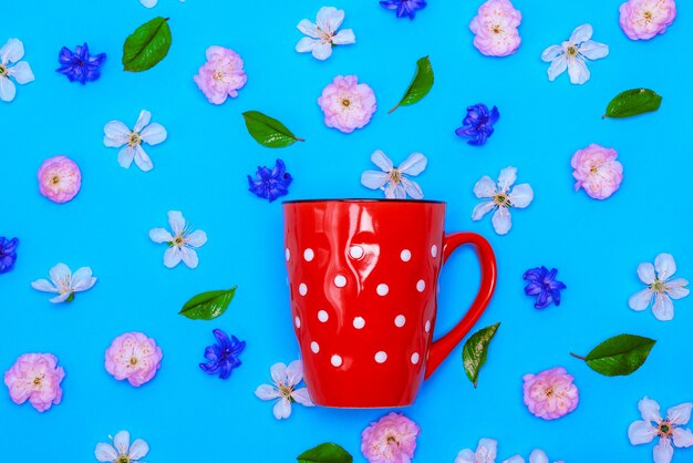 Ceramic red mug  with white polka dots on a blue