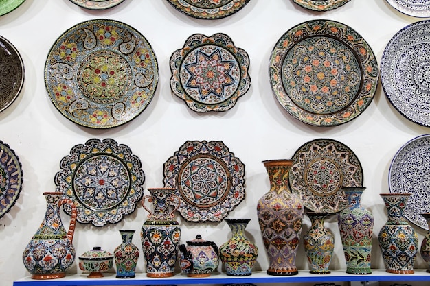 Photo ceramic souvenir plates vases tea sets on the shelves of a store in samarkand in uzbekistan 29042019