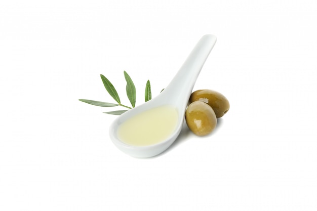 Ceramic spoon with olive oil, olives and leaves isolated on white