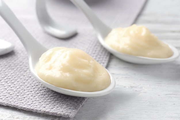 Ceramic spoons with vanilla pudding on table