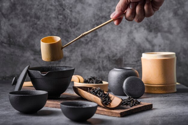 Ceramic tea pot and cups with black herbs