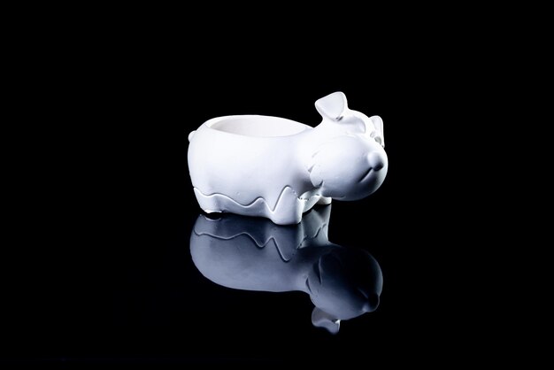 Ceramic vase in the form of a dog with reflection black background isolated