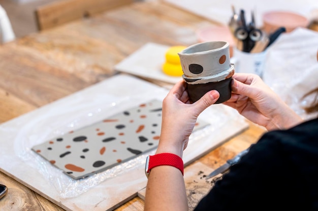 Foto lavori di ceramica closeup delle mani di una donna di mezza età che lavora l'argilla