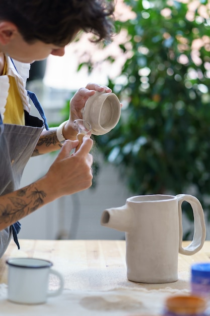 Photo ceramics hobby and small business artisan woman model clay cap for pottery jug in artistic studio