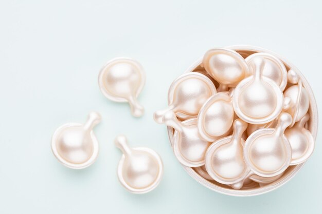 Ceramide anti aging capsules on pastel background.