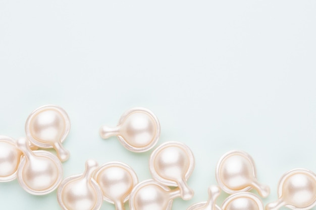 Ceramide anti aging capsules on pastel background.