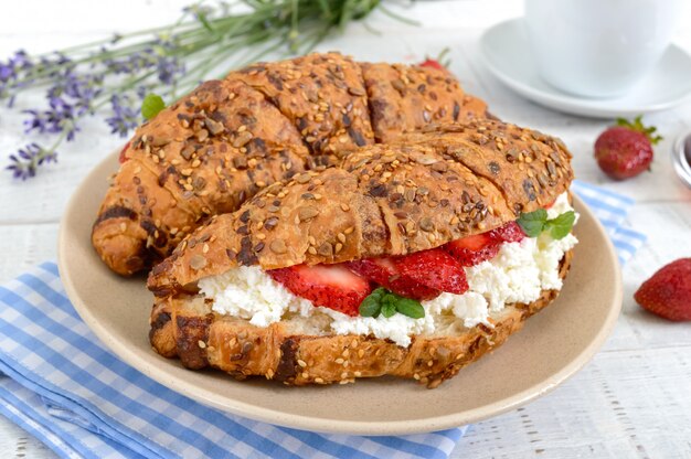 Cereal croissants with cream cheese and fresh strawberries. Useful breakfast. Proper nutrition. French traditional dishes.