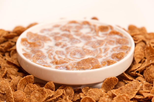 Cereal flakes drenched in milk in a plate closeup