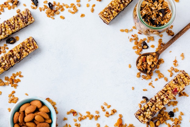 Barretta di cereali muesli con noci, frutta e bacche su un tavolo di pietra bianca. barretta di muesli. snack salutare. vista dall'alto.