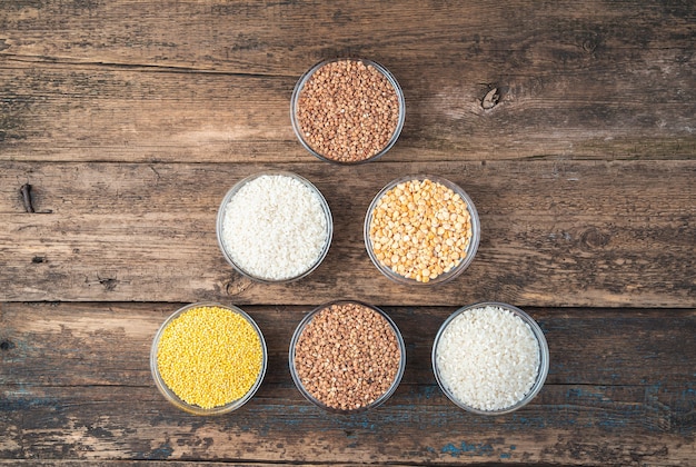 Cereals of different types on a wooden background.