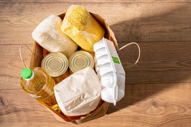 Photo cereals, grains, oil, stew, porridge and canned food groceries in a craft bag for purchases .