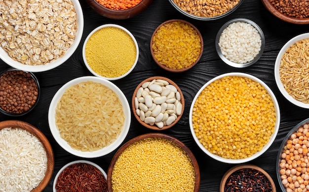 Cereals, grains, seeds and groats black wooden background