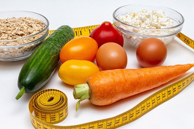 Cereals, measuring tape, farm cottage cheese, carrot, egg, tomatoes, cucumber close up 