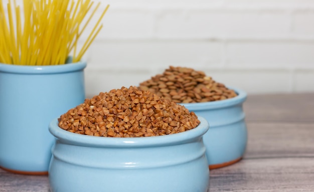 Cereals and pasta in faience blue dishes on a wooden table cooking concept