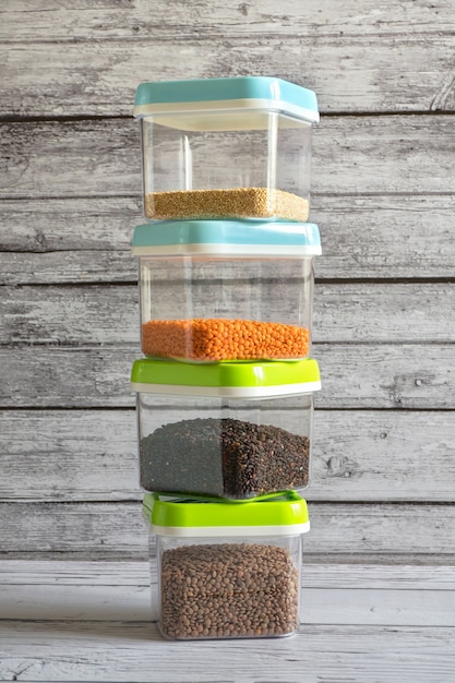 Cereals in plastic containers on a wooden table.