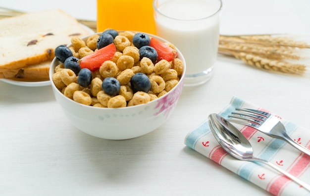 Cereals with blueberries, milk and honey breakfast on a white background