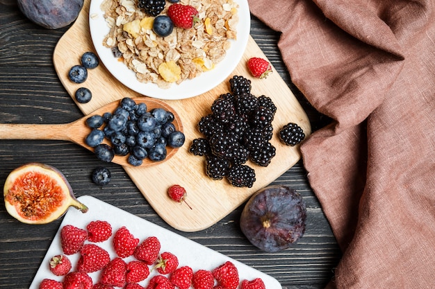 Cereals with fresh berries on a wooden board