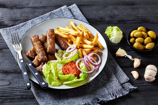 Cevapcici with potato fries lettuce onion ajvar