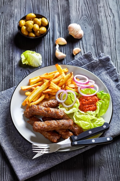 Cevapcici with potato fries lettuce onion ajvar