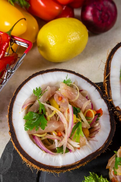 Ceviche 요리 - 코코넛 그릇에 제공되는 열대 과일과 함께 감귤에 절인 신선한 생선의 전채.