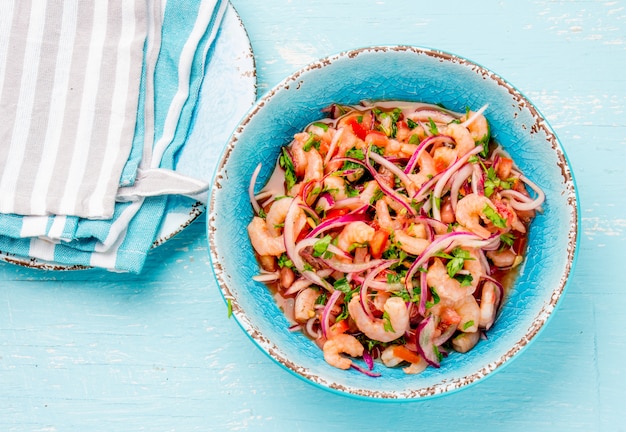 ceviche with tomatoes in a blue bowl