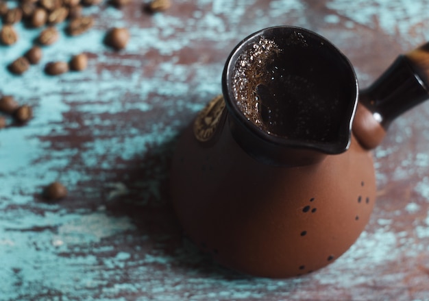 cezve는 파란색 배경에 터키식 커피와 커피 콩을 만드는 냄비입니다