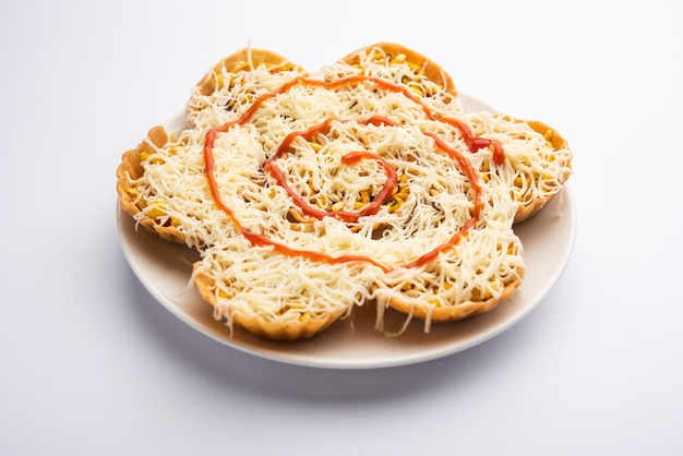 Chaat basket or basket chaat is stuffed with potatos and spices with different chutneys topped with cheese top view selective focus