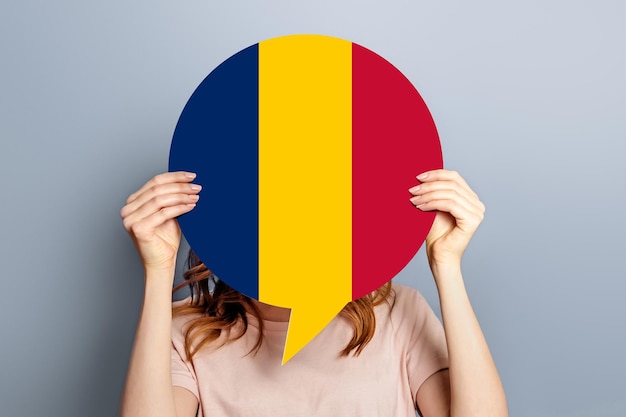 Chad news concept Female hands holding a round information piece of paper dialog with chad flag isolated over grey studio background