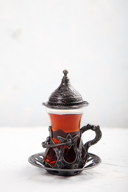 Chaga tea in a Turkish glass on a light background Healthy food concept Copy spaes vertically