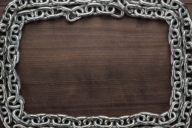 Chain frame on the wooden background