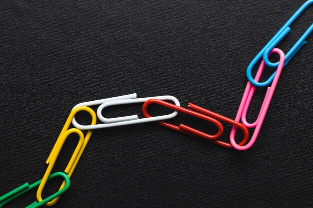 Chain made of paper clips on black background,teamwork and success concept.