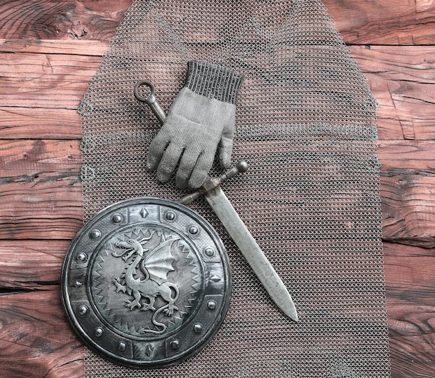 chain mail and sword on a wooden table