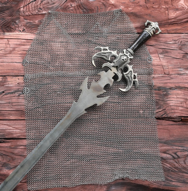 chain mail and sword on a wooden table