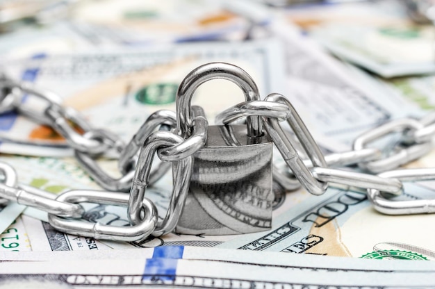 Chain with padlock on the background of dollar bills