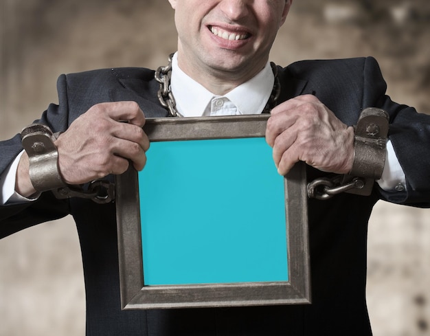 Photo chained businessman with a board