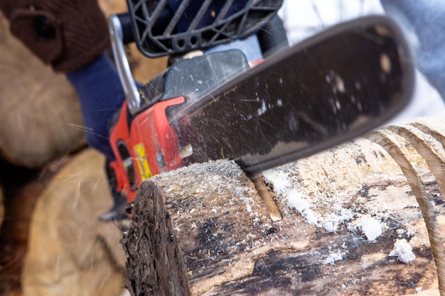 Chainsaw blade cutting log of wood preparation firewood for the\
winter natural living style