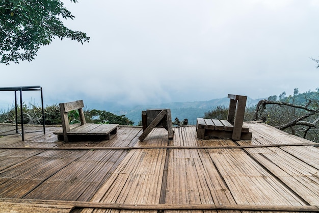 Chair on balcony with mountain hill and foggy background