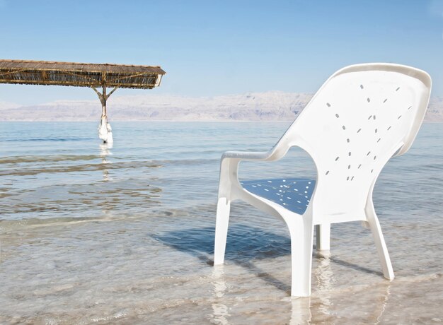 Foto sedile sulla spiaggia contro un cielo limpido