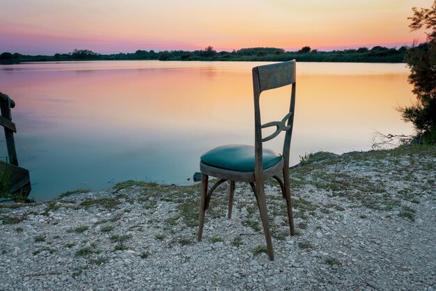 Foto sedile accanto al lago contro il cielo durante il tramonto