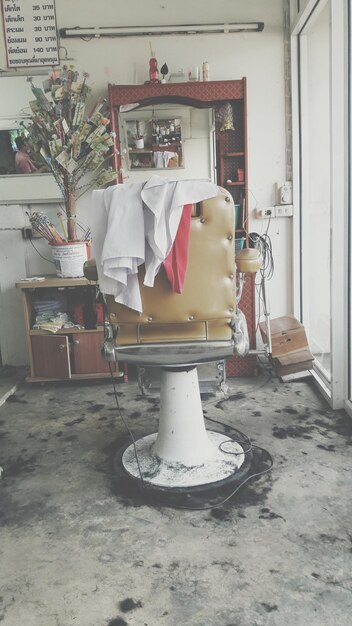 Photo chair on messy floor in barber shop