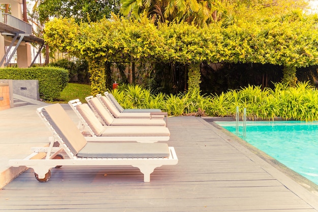 chair pool around swimming pool in hotel resort - holidays and vacations concept