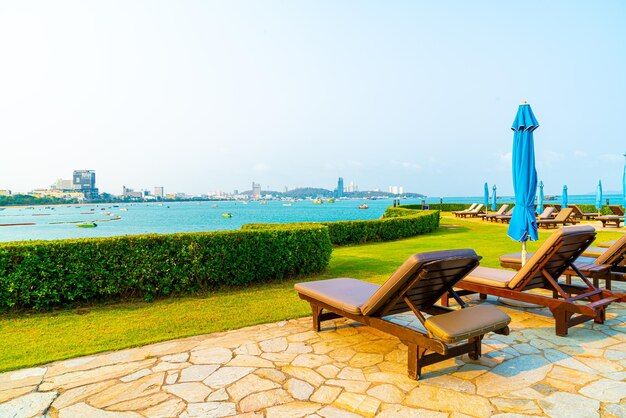 Chair pool or bed pool and umbrella around swimming pool with sea background