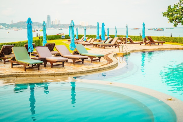 chair pool or bed pool and umbrella around swimming pool with sea beach background
