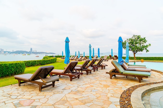 chair pool or bed pool and umbrella around swimming pool with sea beach at Pattaya in Thailand