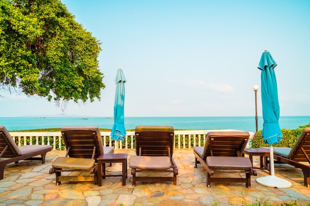 chair pool and umbrella around swimming pool with coconut palm tree - Holidays and vacation concept