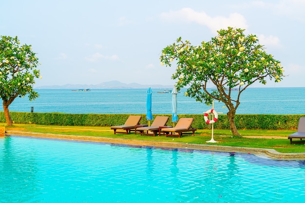 chair pool and umbrella around swimming pool with ocean sea