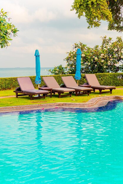 Photo chair pool and umbrella around swimming pool